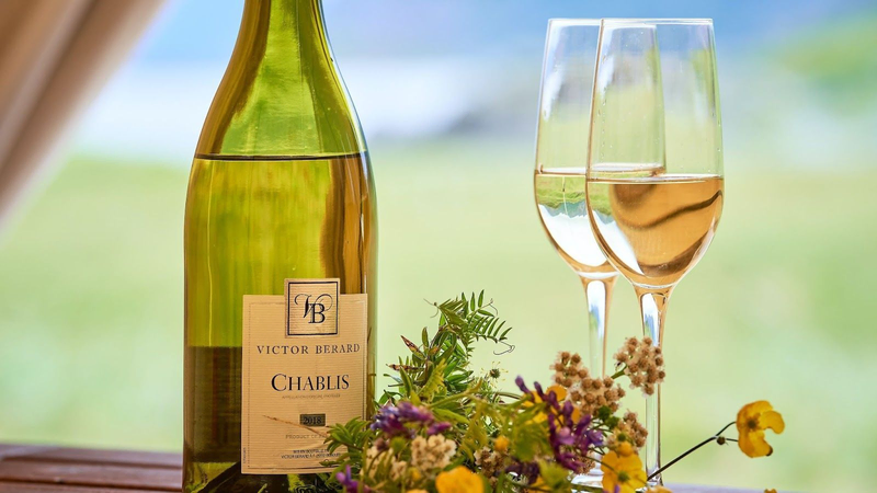 a bottle of Chablis, French white wine, and white wine glasses, from the Villa Pereire wine blog on how to pair wine with oysters