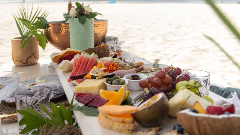 cheese and fruit board by a beach, featured in Villa Pereire’s blog on how to host an apero, a French happy hour