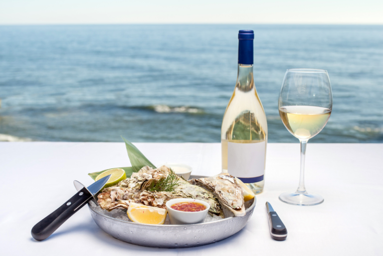 wine and food pairing in the table with a background of the solemn beach