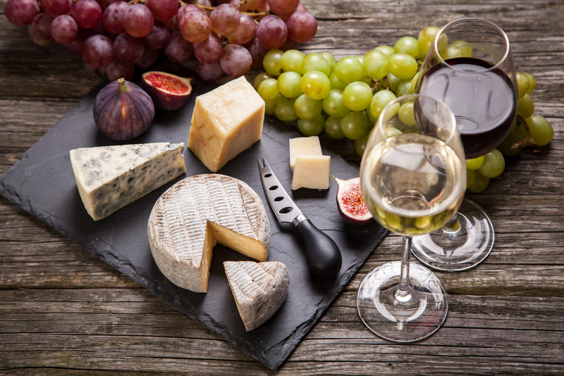 red grapes, green grapes with white and red wine paired with different types of cheese in the table.